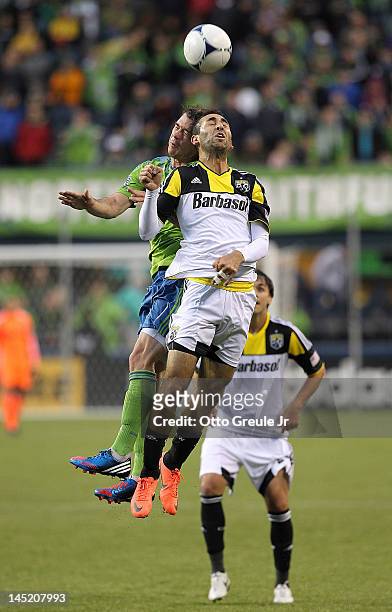 Justin Meram of the Columbus Crew heads the ball against Brad Evans of the Seattle Sounders at CenturyLink Field on May 23, 2012 in Seattle,...