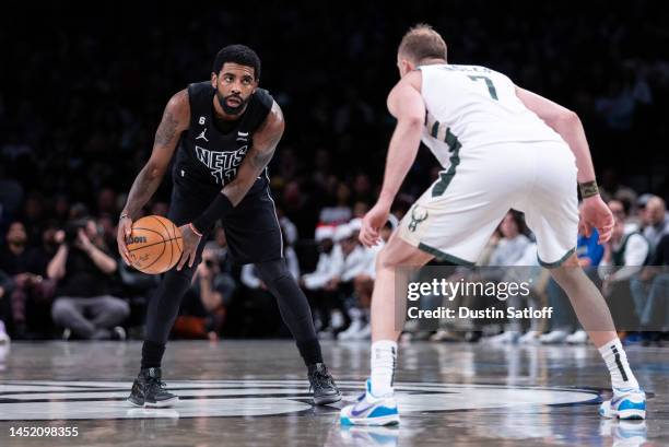 Kyrie Irving of the Brooklyn Nets is guarded by Joe Ingles of the Milwaukee Bucks during the third quarter of the game at Barclays Center on December...