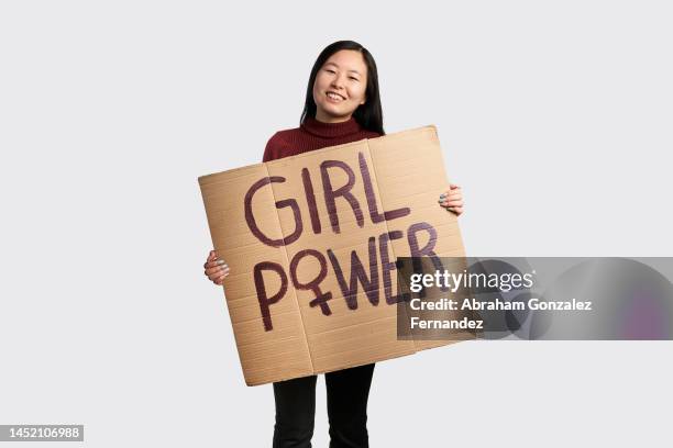 asian woman holding a girl power poster - girl power graphic stock pictures, royalty-free photos & images