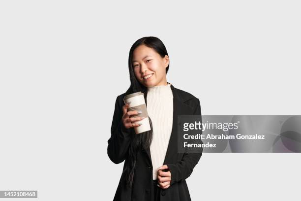 elegant asian woman with a take away coffee - same person different outfits stock-fotos und bilder
