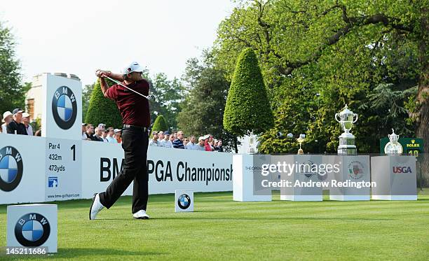 Paul Lawrie of Scotland tees off on the 1st hole in front of the Claret Jug, Ryder Cup, Walker Cup and US Open trophies during the first round of the...