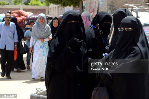 Niqab-clad Egyptian women queue outside a polling station in the Mediterranean city of Alexandria on May 24, 2012. Egyptians swarmed polling stations...