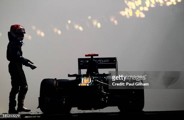 Heikki Kovalainen of Finland and Caterham stands beside his car after its engine blew up in the tunnel during practice for the Monaco Formula One...
