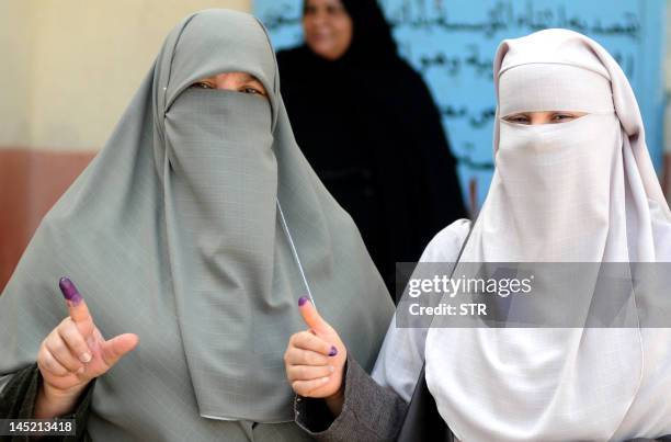 Niqab-clad Egyptian women show their ink-stained fingers after voting at a polling station in the Mediterranean city of Alexandria on May 24, 2012....