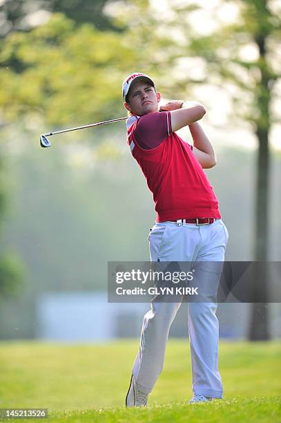 English golfer Tom Lewis watches his approach shot to the 1st green on May 24, 2012 during the first round of the Championship at the Wentworth Golf...