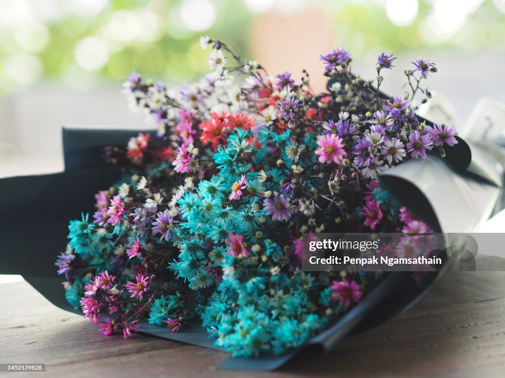 Colorful bouquet of dried flowers Wrapped in blue glossy paper