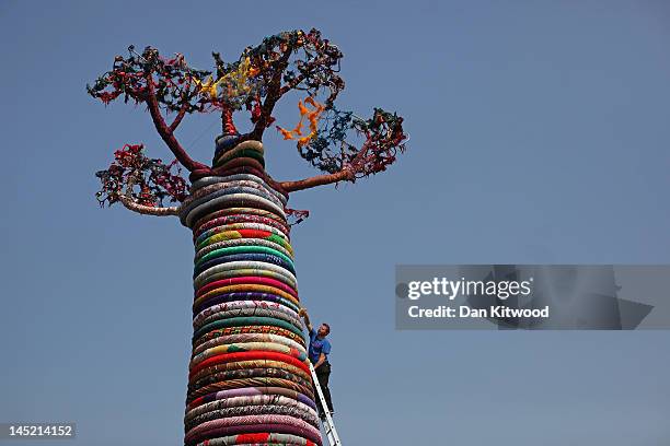 Mike De Butts adds the finishing touches to a giant Baobab Tree sculpture entitled 'Under the Baobab', outside the Southbank Centre on May 24, 2012...