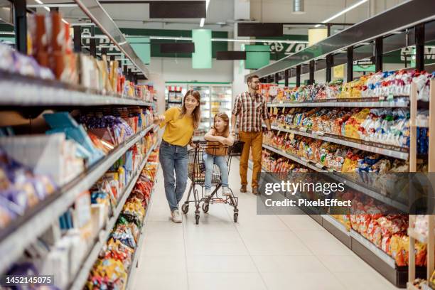 mutter und kleinkind tochter im supermarkt - supermarktgang stock-fotos und bilder