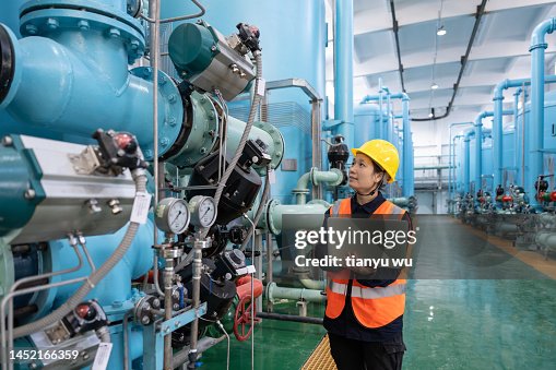 Eine Ingenieurin arbeitet in einer Chemiefabrik mit einem Laptop Eine Ingenieurin arbeitet in einer Chemiefabrik mit einem Laptop