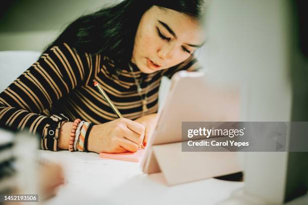 medium shot of teenager studying and doing homeworks - carol grow stock-fotos und bilder