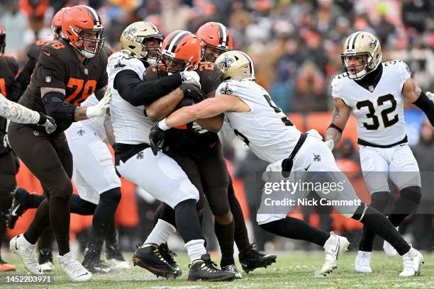 Nick Chubb of the Cleveland Browns is tackled by Shy Tuttle and Kaden Elliss of the New Orleans Saints during the first half at FirstEnergy Stadium...