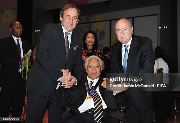 Winston Chung receives the Order of Merit Award from FIFA President Joseph S. Blatter and UEFA President Michel Platini during the 62nd FIFA Congress...