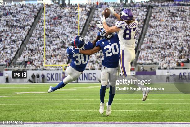 Hockenson of the Minnesota Vikings catches a touchdown pass over Darnay Holmes of the New York Giants and Julian Love of the New York Giants during...