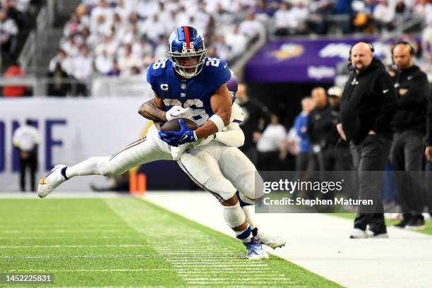 Patrick Peterson of the Minnesota Vikings tackles Saquon Barkley of the New York Giants during the third quarter at U.S. Bank Stadium on December 24,...