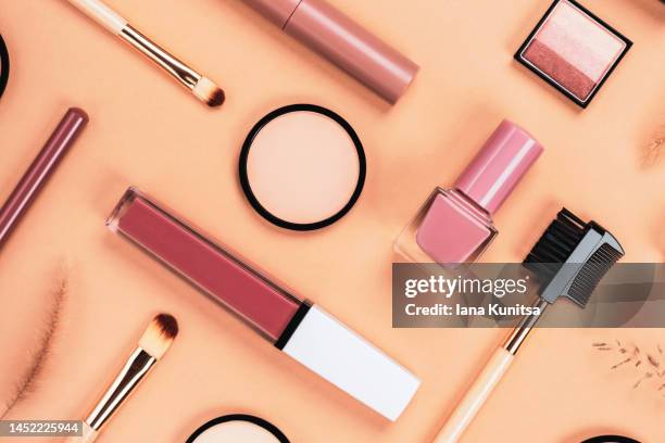 set of different makeup accessories on beige, brown background. cosmetic products for skin care. eyeshadow, blush, face powder, nail polish, brushes and lipstick. - cosmetic stockfoto's en -beelden