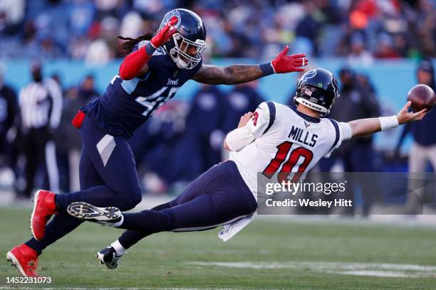 Davis Mills of the Houston Texans throws the ball while being pressured by Bud Dupree of the Tennessee Titans during the second half at Nissan...