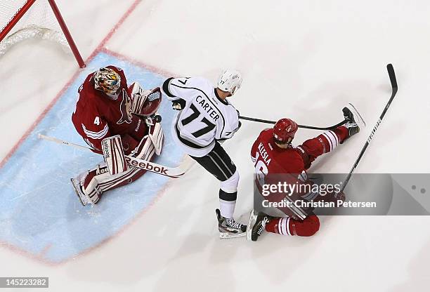 Goaltender Mike Smith of the Phoenix Coyotes makes a save on the shot as Jeff Carter of the Los Angeles Kings looks for a rebound in Game Five of the...