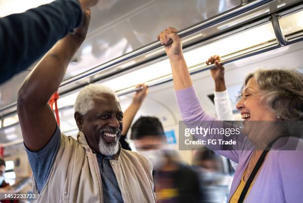 amigos mais velhos conversando no trem do metrô - grade de proteção - fotografias e filmes do acervo