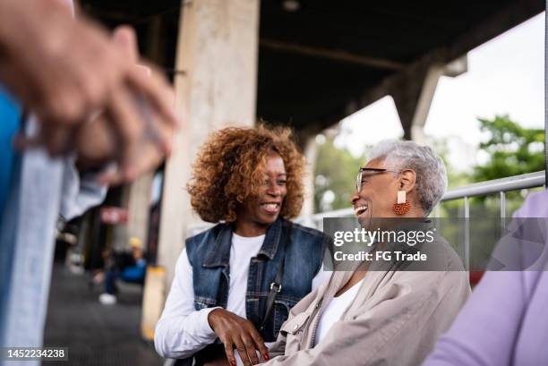 senior friend talking in the subway station - belong stock pictures, royalty-free photos & images