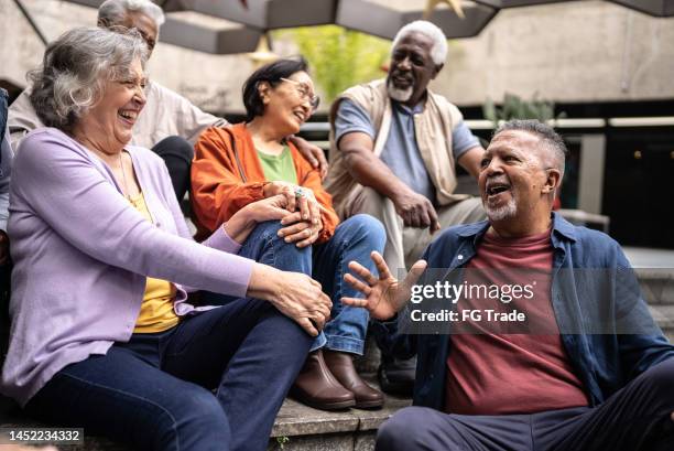senior friends talking outdoors - grupo multiétnico imagens e fotografias de stock