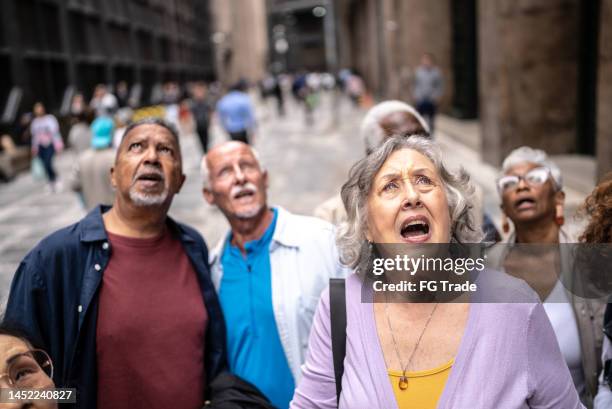 shocked senior tourists looking up outdoors - apocalyptic bildbanksfoton och bilder