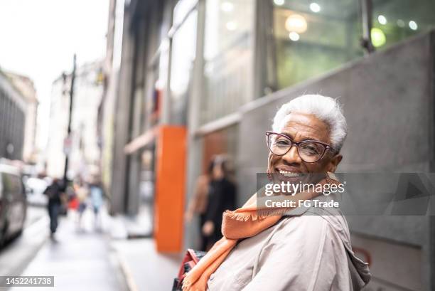 portrait of a senior woman walking outdoors - senior women walking stock pictures, royalty-free photos & images