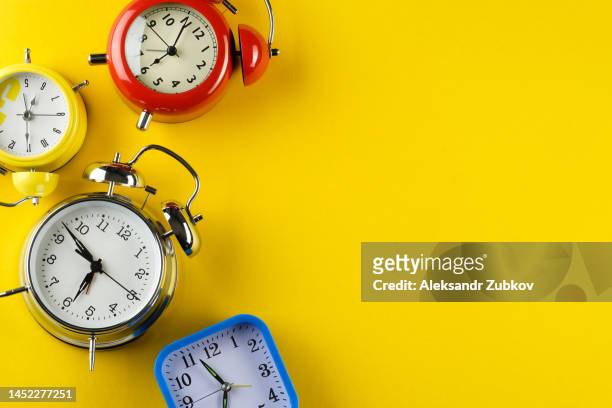 a collection of colorful alarm clocks in retro and vintage style on a bright yellow background. the concept of the speed and rapidity of time and the flow of life. banner. copy space. - countdown concept stock pictures, royalty-free photos & images
