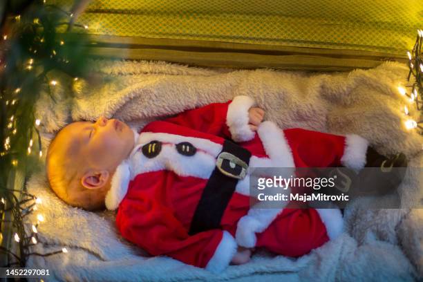 baby boy lying in suitcase under christmas tree - alleen één jongensbaby stockfoto's en -beelden