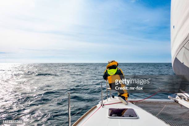 female sailor keeping an eye out on a catamaran - catamaran sailing stock pictures, royalty-free photos & images