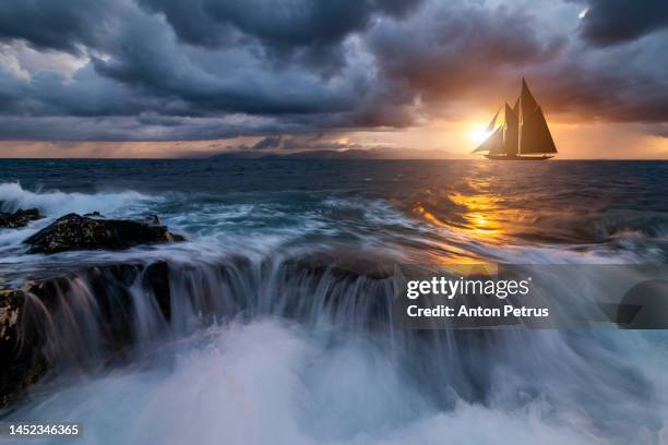beautiful sailboat at sunset in a stormy sea - seascape stock pictures, royalty-free photos & images