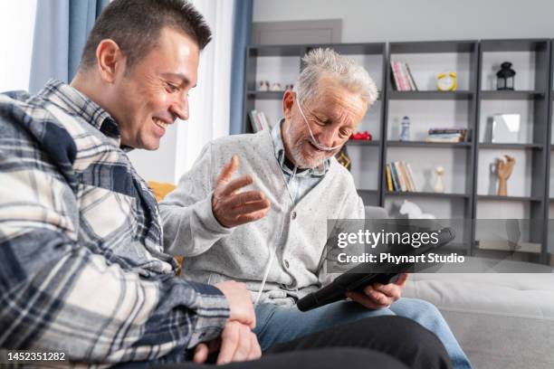 senior man takes help in digital tablet from a young man - zuurstofapparaat stockfoto's en -beelden