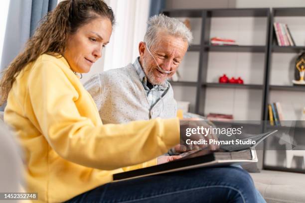 grandad showing his daughter memories from past - nasal cannula stock pictures, royalty-free photos & images