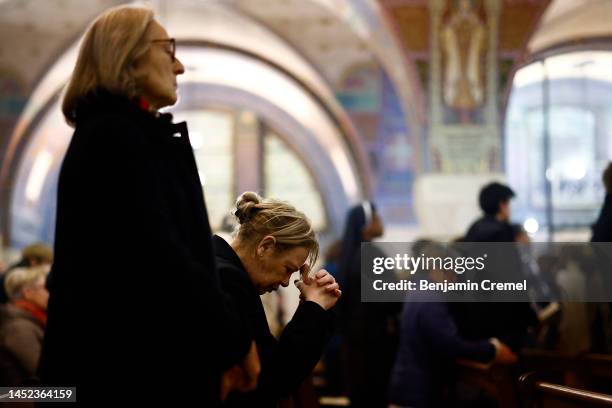 Worshippers pray during the Christmas Eve mass inside the Crypt of the Basilica of Saint Therese of Lisieux on December 24, 2022 in Lisieux, France....