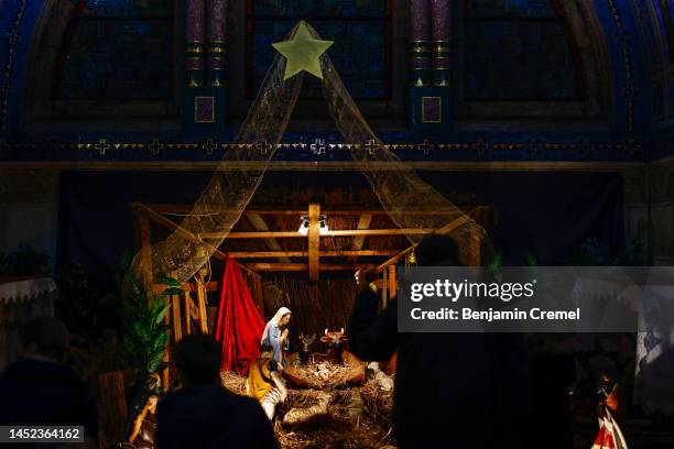 Visitors look at a Nativity Scene displayed inside the Crypt of the Basilica of Saint Therese of Lisieux on Christmas Day on December 25, 2022 in...