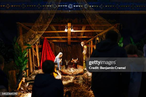 Visitors look at a Nativity Scene displayed inside the Crypt of the Basilica of Saint Therese of Lisieux on Christmas Day on December 25, 2022 in...