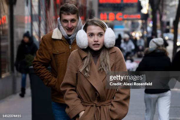 Woman dressed in winter clothing and large earmuffs walks near Rockefeller Center on Christmas Day on December 25, 2022 in New York City. Most of the...