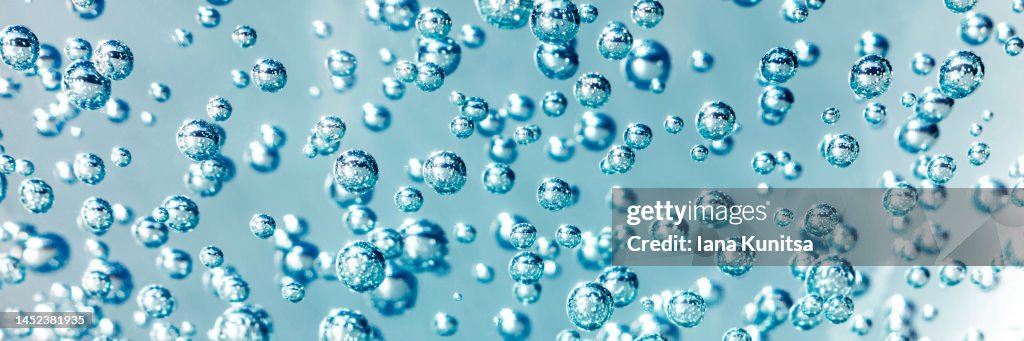 Transparent blue, turquoise carbonated water with bubbles. Concept of hydration and freshness. Cosmetic products for makeup and skin care. Beauty banner.
