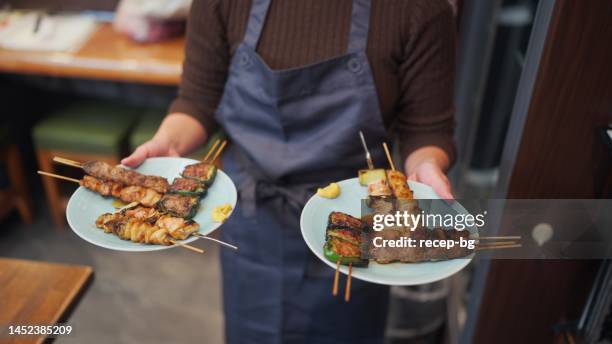 close-up photo of waitress carrying food - izakaya food stock pictures, royalty-free photos & images