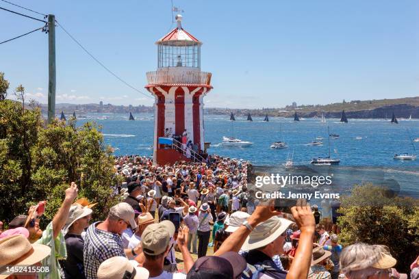 Spectators look on and photograph the race start during the 2022 Sydney to Hobart on Sydney Harbour, on December 26, 2022 in Sydney, Australia.