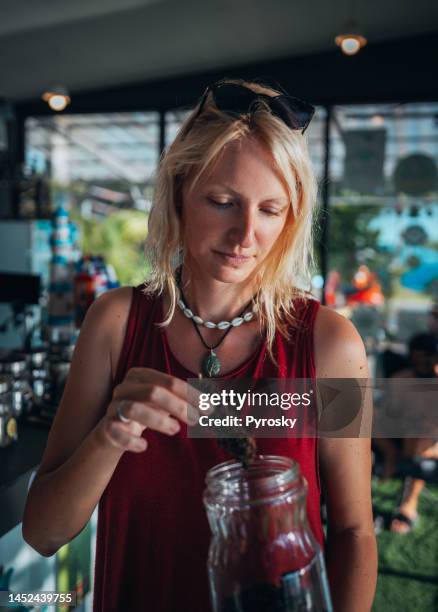 female holding cannabis buds - marijuana decriminalization stock pictures, royalty-free photos & images