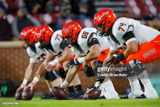 Centers Preston Wilson, Joe Michalski, and Eli Russ of the Oklahoma State Cowboys prepare to snap the ball before Bedlam against the Oklahoma Sooners...