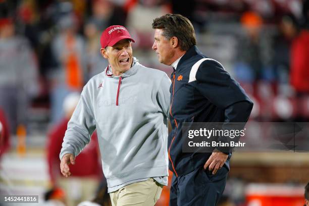 Head coach Brent Venables of the Oklahoma Sooners talks with head coach Mike Gundy of the Oklahoma State Cowboys before Bedlam at Gaylord Family...