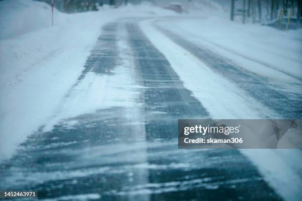 snow falling  to cover the road on the way from sapporo to niseko ski resort near mount yotei hokkaido japan - snow road stock-fotos und bilder