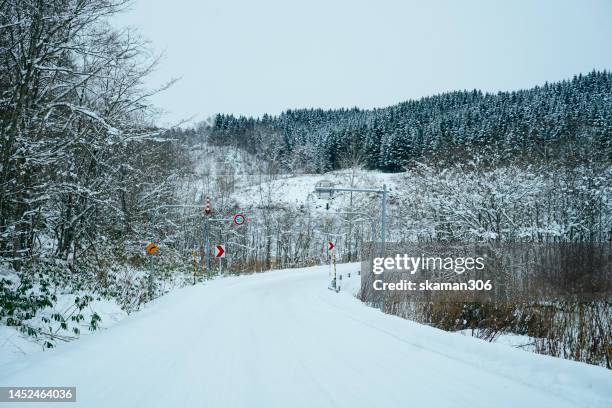 snow falling  to cover the road on the way from sapporo to niseko ski resort near mount yotei hokkaido japan - sapporo japan fotografías e imágenes de stock