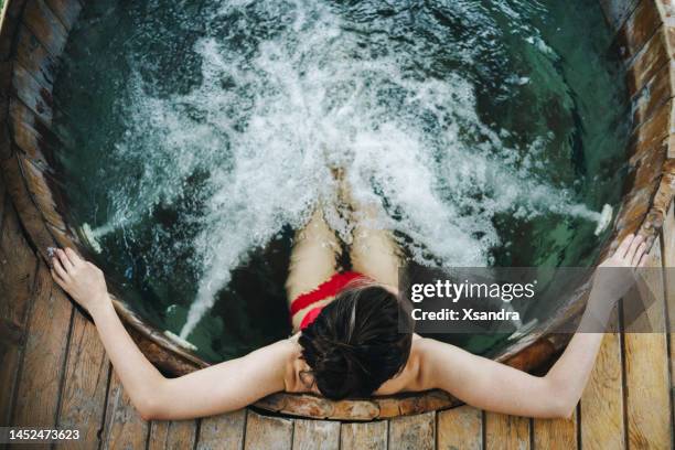 frau entspannt sich im outdoor-spa - whirlpool stock-fotos und bilder