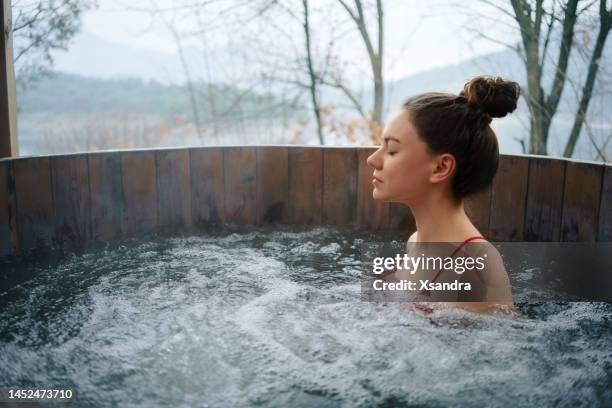 mulher, relaxante na banheira de hidromassagem ao ar livre - hot tub - fotografias e filmes do acervo