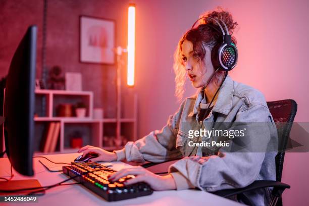 young woman plays video game online and streaming at home - gamers stockfoto's en -beelden