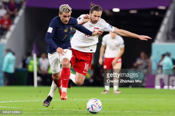 Antoine Griezmann of France competes for the ball with Grzegorz Krychowiak of Poland during the FIFA World Cup Qatar 2022 Round of 16 match between...