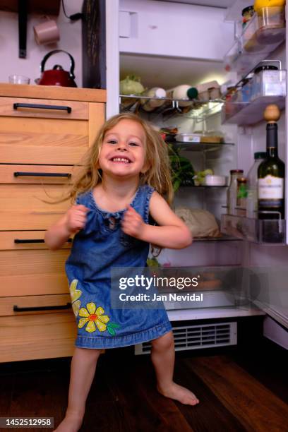 happy small girl  dancing in front of a full fridge - jan dance 個照片及圖片檔