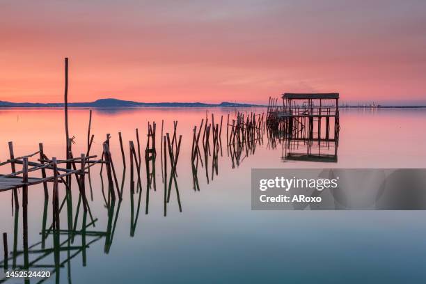 amazing sunset on the palatial pier of carrasqueira, alentejo, portugal. wooden artisanal fishing port, with traditional boats on the river sado. fineart color horizontal photography. - alentejo photos et images de collection